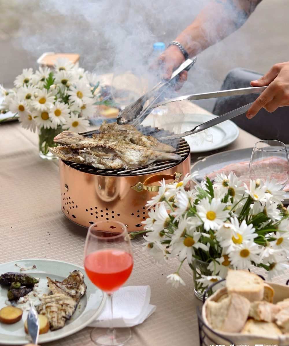 Poisson grillé sur table dressée avec fleurs et vin