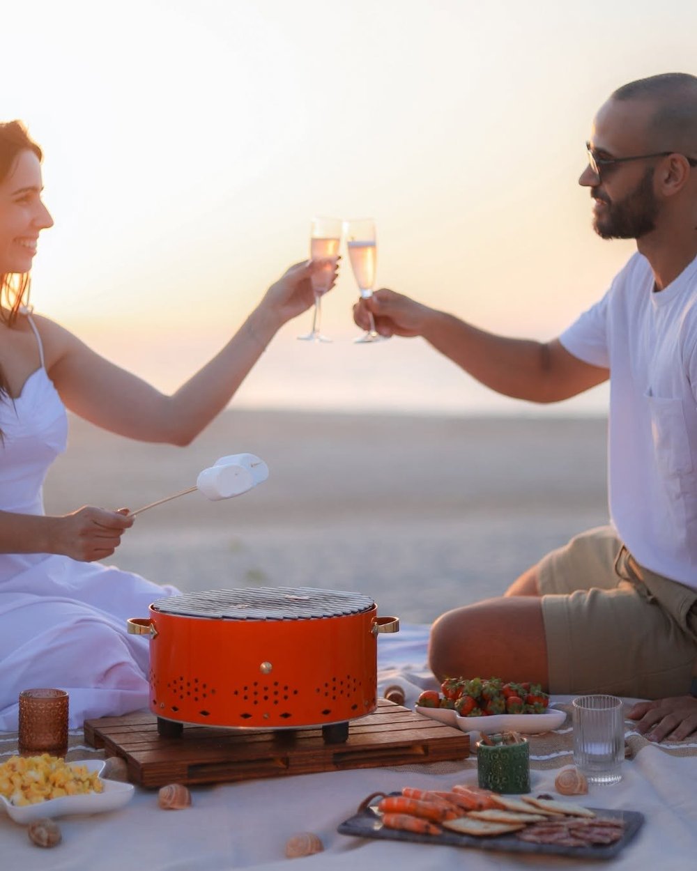 Couple trinquant au coucher du soleil devant la grille